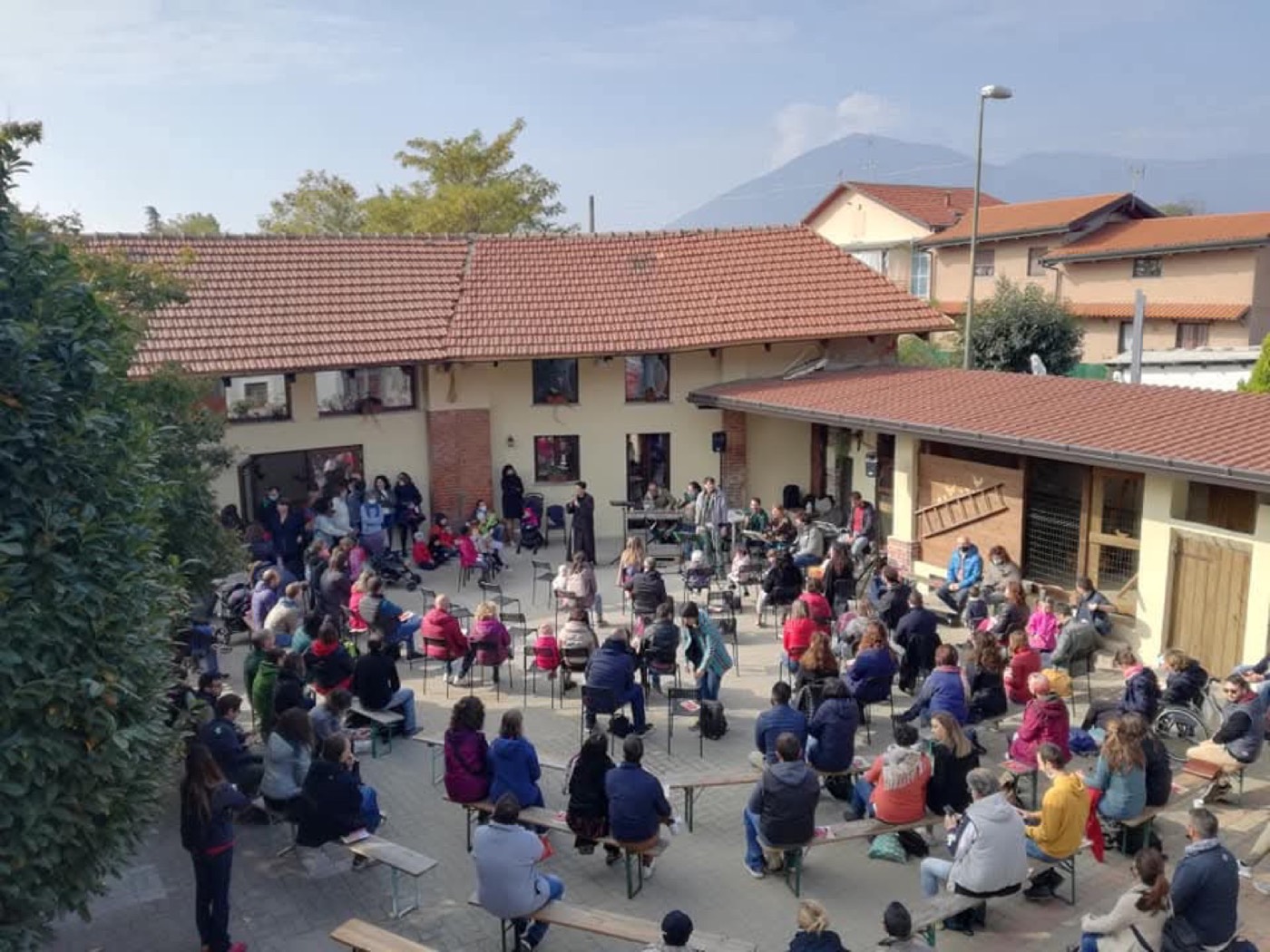 Famiglie e bambini riuniti nel cortile di Cascina Frate Lupo
